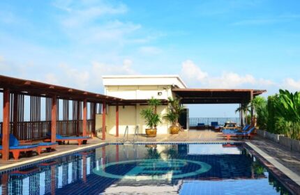 Baywalk Residence gay-friendly hotel pool. Rooftop pool with lounge chairs and clear blue sky. Ideal for gay travel and relaxation.