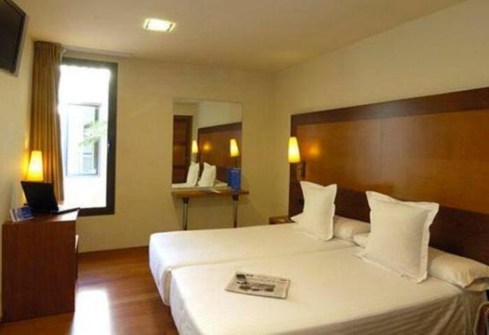 BCN Urbany Hotels Del Comte room. Gay-friendly hotel with twin beds, desk, TV, and modern decor. A comfortable stay in Barcelona.