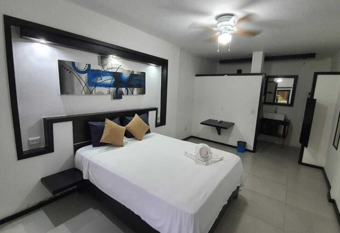 Beach Energy Hotel By BFH room. Gay-friendly hotel with bed, modern decor, and bathroom. Ideal for gay men's travel. Stylish, relaxing stay.