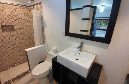 Bathroom at Beach Energy Hotel By BFH, a gay-friendly hotel. Features a tiled shower, toilet, and modern sink with mirror. #gaytravel