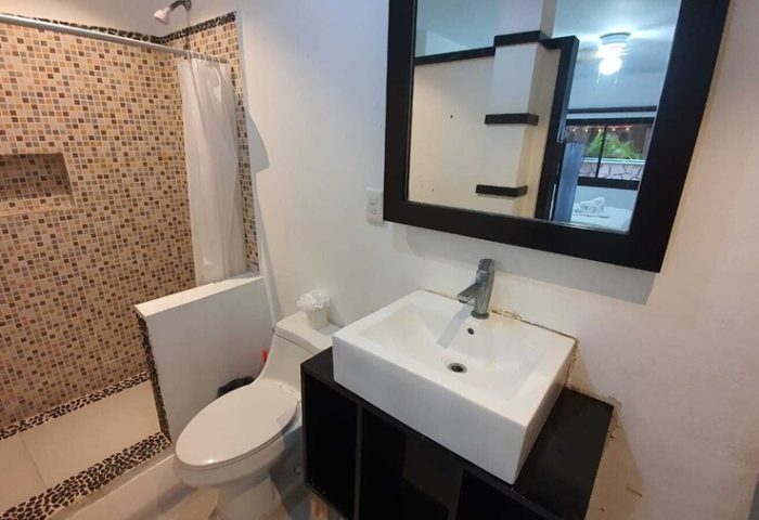 Bathroom at Beach Energy Hotel By BFH, a gay-friendly hotel. Features a tiled shower, toilet, and modern sink with mirror. #gaytravel