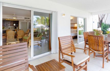 Beachscape Kin Ha Villas & Suites Cancun patio. Gay-friendly hotel with outdoor seating, table, and chairs. View of the suite interior.