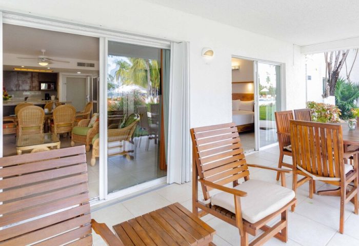 Beachscape Kin Ha Villas & Suites Cancun patio. Gay-friendly hotel with outdoor seating, table, and chairs. View of the suite interior.