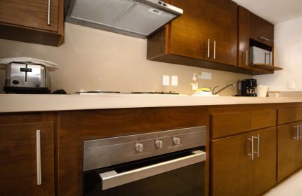Beachscape Kin Ha Villas & Suites Cancun kitchen. Gay-friendly hotel suite with oven, stove, microwave, toaster, coffee maker, and sink.