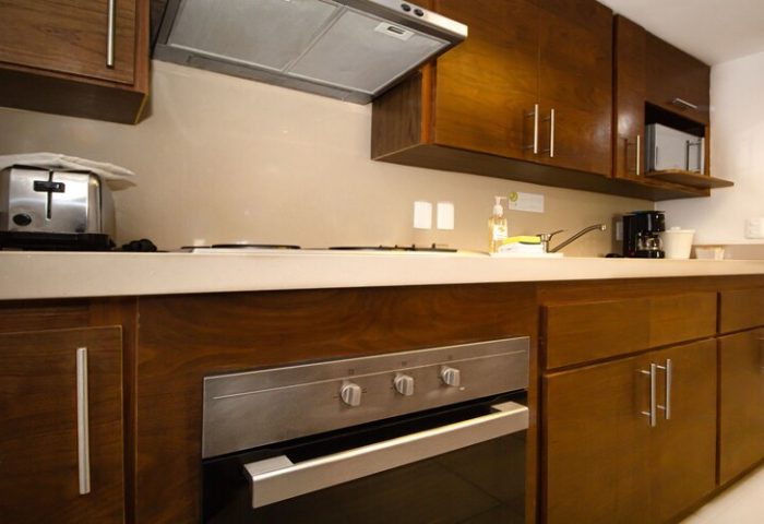 Beachscape Kin Ha Villas & Suites Cancun kitchen. Gay-friendly hotel suite with oven, stove, microwave, toaster, coffee maker, and sink.
