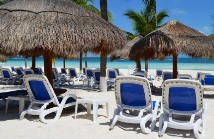 Beachscape Kin Ha Villas & Suites Cancun beach view. Gay-friendly hotel with chairs, umbrellas, white sand, & blue ocean. Perfect for gay travel.