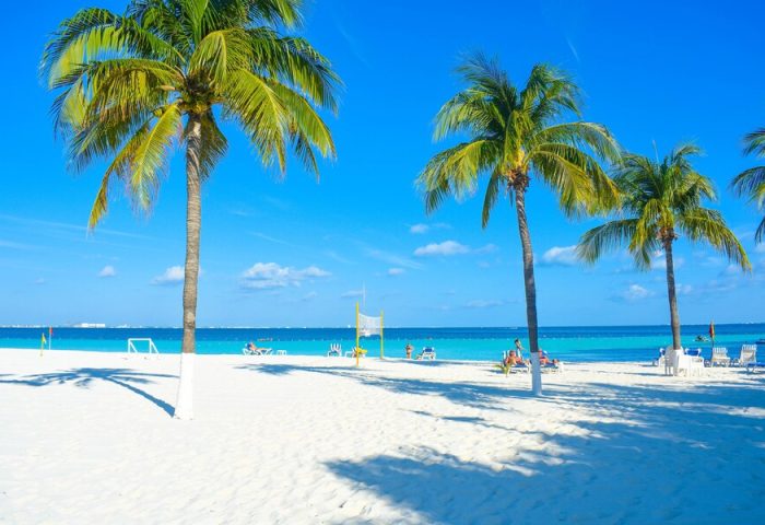 Beachscape Kin Ha Villas & Suites Cancun: Palm trees on white sand beach. Gay-friendly hotel in Cancun, turquoise water, blue sky.