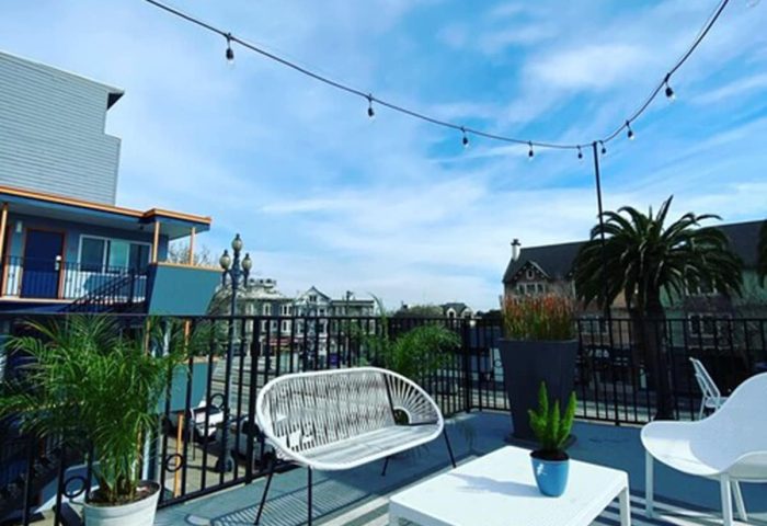 Beck's Motor Lodge gay-friendly hotel patio. Outdoor seating, string lights, and potted plants create a relaxing atmosphere. Travel advice.