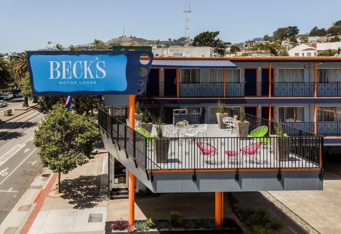 Beck's Motor Lodge, a gay-friendly hotel in San Francisco. Features a retro sign, colorful decor, and a communal outdoor patio.