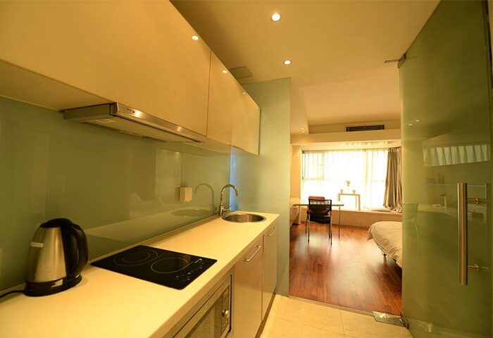 Beijing New Oriental Suites kitchen view. Gay-friendly hotel in Seasons Park Sanlitun, China. Modern kitchenette with appliances.