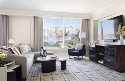 Bellagio Hotel suite interior. Gay-friendly hotel room with city view, sofa, chair, and TV. Upscale Las Vegas lodging for gay men.