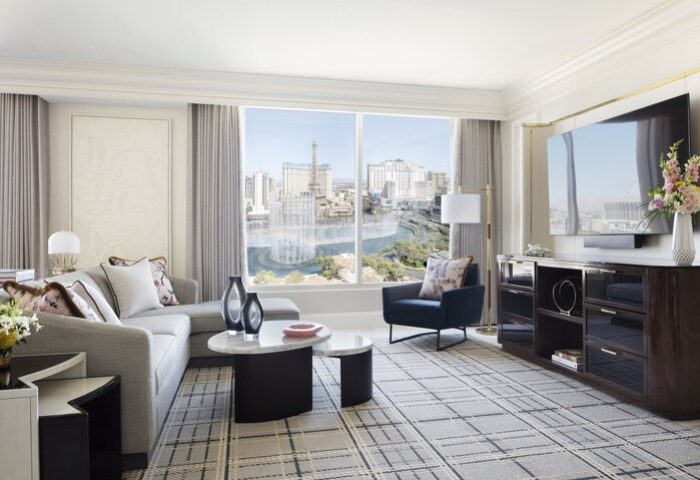 Bellagio Hotel suite interior. Gay-friendly hotel room with city view, sofa, chair, and TV. Upscale Las Vegas lodging for gay men.
