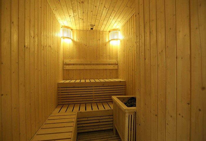 Sauna room at the gay-friendly Belmont Hotel Manila. Wooden benches and walls, plus soft lighting, create a relaxing spa experience.