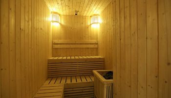 Sauna room at the gay-friendly Belmont Hotel Manila. Wooden benches and walls, plus soft lighting, create a relaxing spa experience.