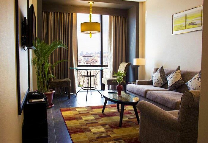 Belmont Hotel Manila suite. Gay-friendly hotel room with sofa, table, and city view. A comfortable stay for gay travelers.
