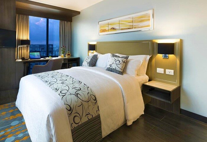 Bedroom at Belmont Hotel Manila, a gay-friendly hotel. Queen bed, desk, city view. Comfortable stay for LGBTQ+ travelers.