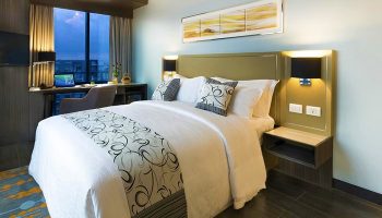 Bedroom at Belmont Hotel Manila, a gay-friendly hotel. Queen bed, desk, city view. Comfortable stay for LGBTQ+ travelers.