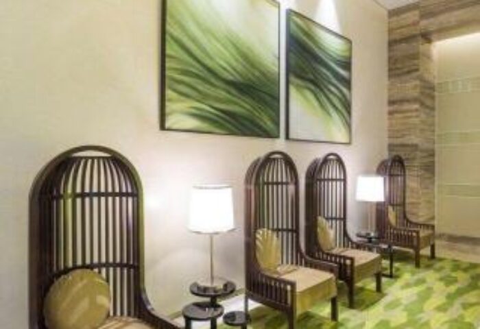 Belmont Hotel Manila lobby seating area. Gay-friendly hotel with stylish chairs, green leaf carpet, and modern art. Comfortable, welcoming space.