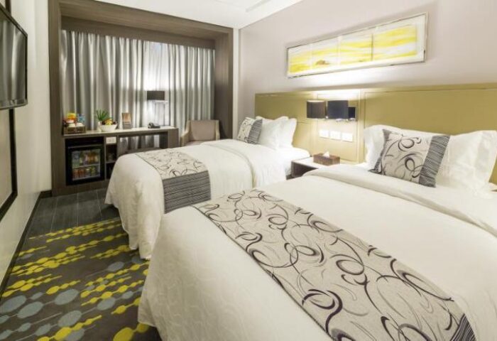 Belmont Hotel Manila twin room. Gay-friendly hotel with two beds, desk, mini-fridge, and modern decor. A comfortable stay for gay travelers.