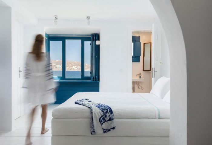 Belvedere Little Venice Pied-a-Terres: Bright, white bedroom with blue accents, sea view, and blurred figure. Gay-friendly hotel interior.