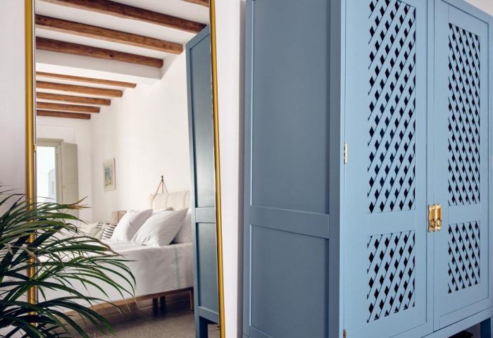 Belvedere Mykonos Hilltop Complex room detail. Blue wardrobe and mirror reflecting the bed. Gay-friendly hotel interior.