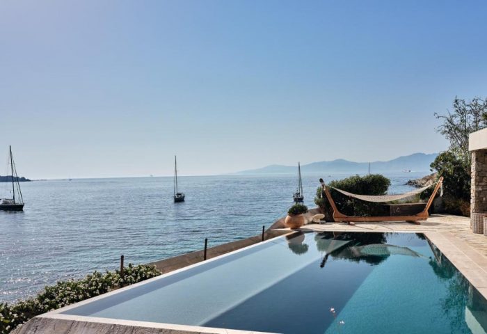 Belvedere Mykonos Waterfront Villa Suites pool view. Gay-friendly travel destination with sea view, yachts, and hammock.