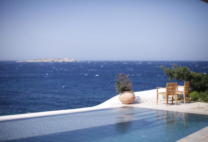 Belvedere Mykonos waterfront villa suites view. Gay-friendly hotel pool overlooking the Aegean Sea. Luxury travel destination.