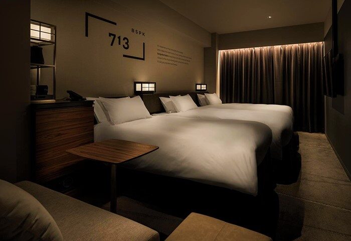 Bespoke Hotel Shinjuku room. Gay-friendly hotel with two beds, bedside tables, and dark curtains. Modern design for gay travelers in Tokyo.