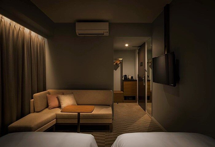 Bespoke Hotel Shinjuku room interior. Gay-friendly hotel with a modern design, featuring a cozy lounge area and sleek TV. Perfect for gay travelers.