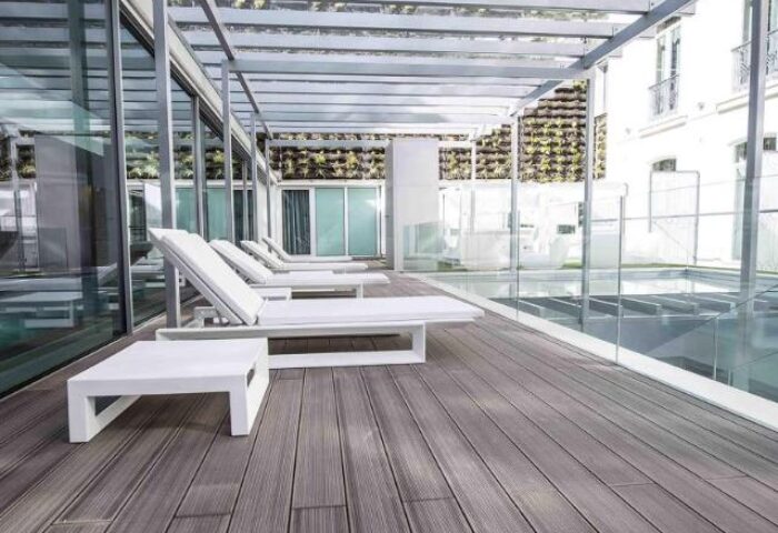 BessaHotel Liberdade's pool area. Gay-friendly hotel with sun loungers, glass walls, and a modern design. Perfect for gay travelers' relaxation.