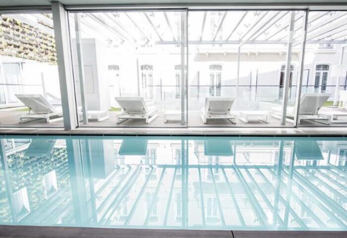 BessaHotel Liberdade's pool area. This gay-friendly hotel features a bright, modern pool with lounge chairs, perfect for relaxing.