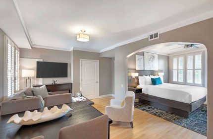 Best Western Plus Hawthorne Terrace Hotel gay-friendly suite. Room with bed, TV, table, and chairs. Modern design for gay travelers.