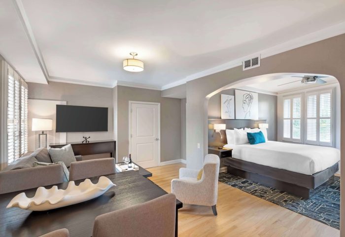 Best Western Plus Hawthorne Terrace Hotel gay-friendly suite. Room with bed, TV, table, and chairs. Modern design for gay travelers.