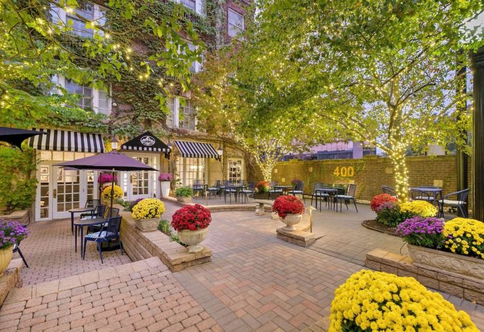 Hawthorne Terrace Hotel courtyard. Outdoor seating, flowers, and lights create a welcoming space at this gay-friendly Best Western Plus.