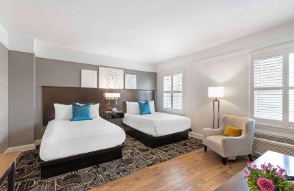 Best Western Plus Hawthorne Terrace Hotel room with two beds, chair, and modern decor. Gay-friendly hotel for gay men's travel.