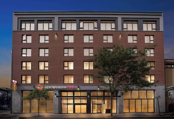 Best Western Plus Hotel Montreal, a gay-friendly hotel. Exterior view of the brick building at dusk, offering accommodations for gay travelers.