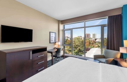 Best Western Plus Hotel Montreal guest room. Gay-friendly hotel with city view, desk, TV, and comfortable chair. Modern interior design.
