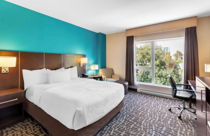 Bedroom at the Gay-Friendly Best Western Plus Hotel Montreal. King bed, desk, chair, and a view. A great choice for gay travelers.