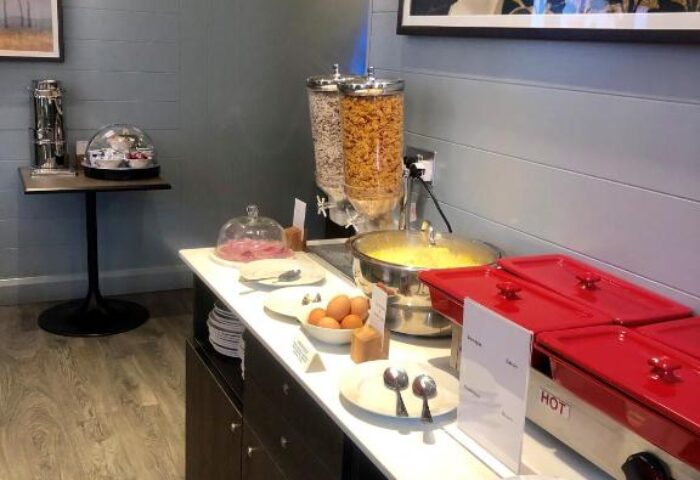 Breakfast buffet at Best Western Plus Vauxhall Hotel, a gay-friendly hotel. Cereal, eggs, hot dishes, plates, and utensils are visible.