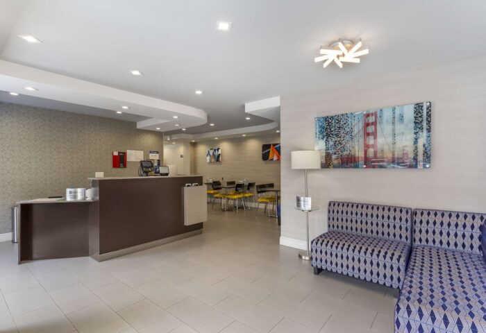 Best Western Red Coach Inn lobby. Gay-friendly hotel with modern decor, reception desk, seating area, and Golden Gate Bridge art.