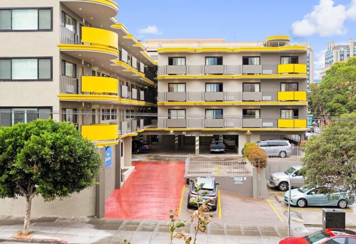 Best Western Red Coach Inn, a gay-friendly hotel. Exterior view of the building with yellow accents, parking area, and street view.