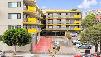 Best Western Red Coach Inn, a gay-friendly hotel. Exterior view of the building with yellow accents, parking area, and street view.