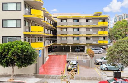 Best Western Red Coach Inn, a gay-friendly hotel. Exterior view of the building with yellow accents, parking area, and street view.