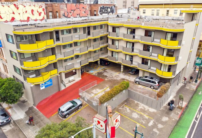 Best Western Red Coach Inn, a gay-friendly hotel. The hotel's exterior features yellow accents and a red entrance. Parking available.
