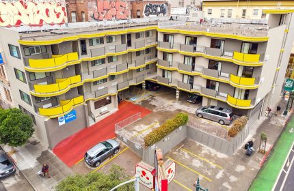Best Western Red Coach Inn, a gay-friendly hotel. The hotel's exterior features yellow accents and a red entrance. Parking available.
