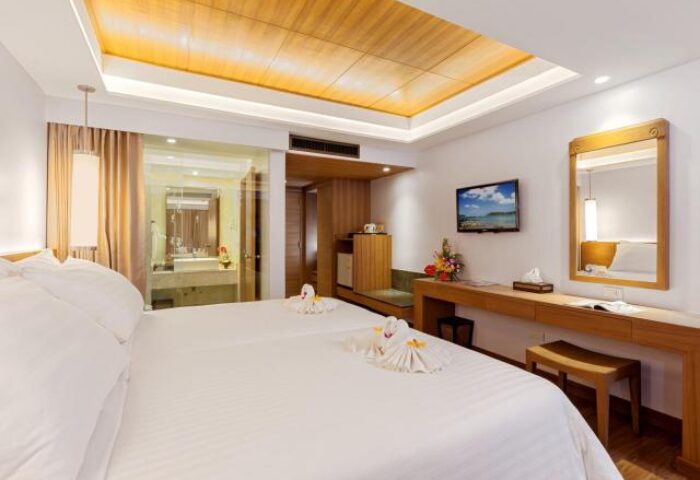 Beyond Resort Karon's gay-friendly hotel room. Modern design, white linens, swan towels, TV, and bathroom view. Ideal for gay travel.