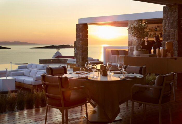 Bill & Coo Suites and Lounge, a gay-friendly hotel. Sunset view from the restaurant's terrace. The bar and lounge are visible. Mykonos.