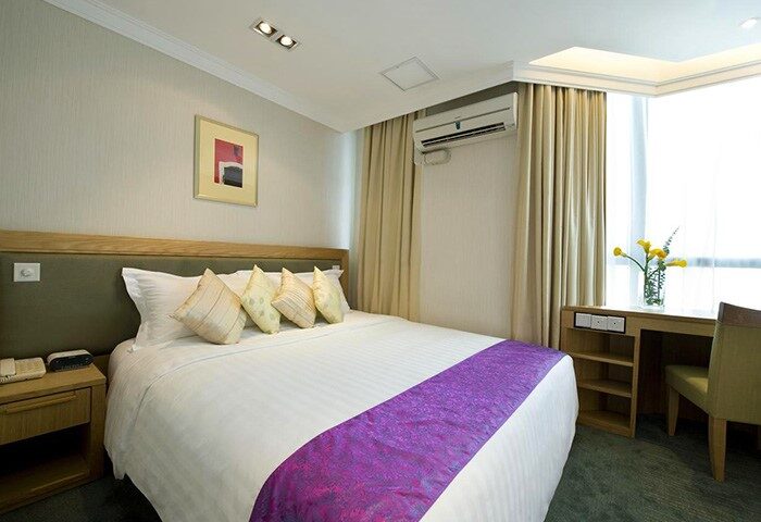 Bishop Lei International House room. Gay-friendly hotel with bed, desk, and air conditioning. Modern decor. Comfortable stay for gay travelers.