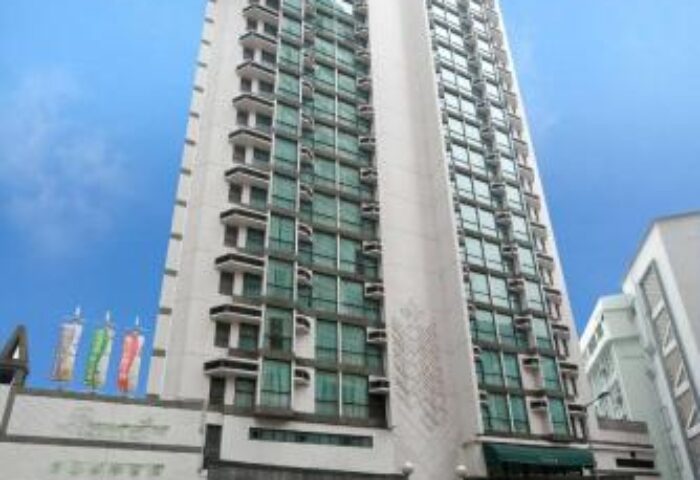 Bishop Lei International House, a gay-friendly hotel in Hong Kong. Tall building with many windows, seen from the street.
