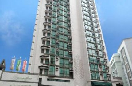 Bishop Lei International House, a gay-friendly hotel in Hong Kong. Tall building with many windows, seen from the street.